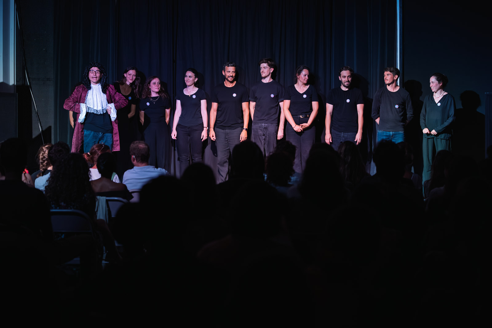 Troupe alignée sur scène face au public